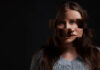 When Treatment Fails: Why I Relate to Lindsay Clancy Studio shot of a woman posing against a dark background with a distorted face.