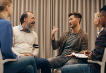 Open Dialogue and ODDESSI: What Have We Learned? Group of people sitting on chairs in circle and discussing some problems together during therapy lesson