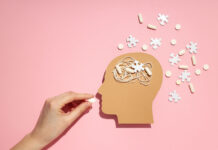 A Call for a Paradigm Shift in Schizophrenia Treatment: Reassessing Long-Term Antipsychotic Use and the Evidence for Psychosocial Interventions Illustration of hand feeding pill to head with puzzle pieces around it
